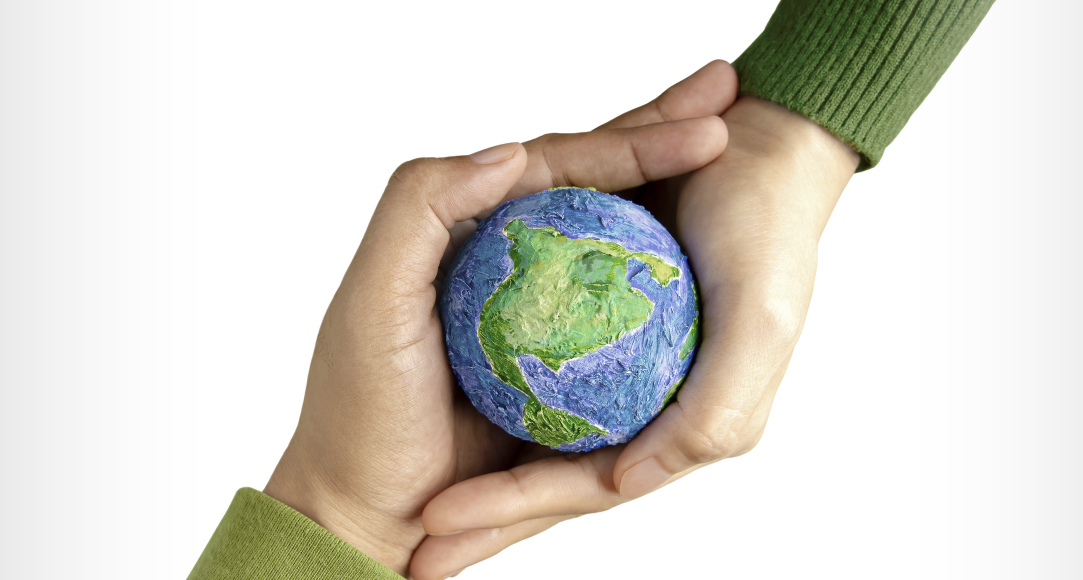 Zwei Hände halten eine kleine Weltkugel